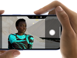 Użytkownik robi zdjęcie za pomocą trzymanego w dłoni iPhone’a 16