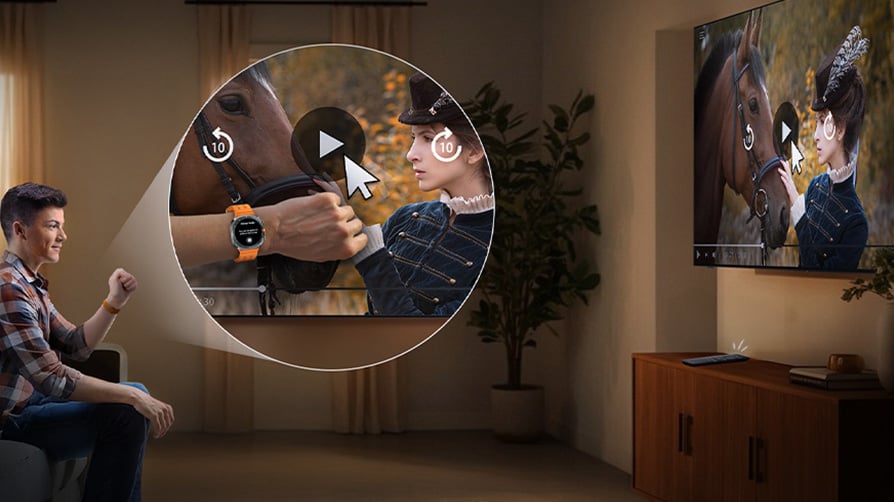PMężczyzna z Galaxy Watch ogląda TV w salonie. Porusza ręką w tę i z powrotem, aby sterować odtwarzaniem filmu na ekranie telewizora Samsung Mini LED Neo QLED.